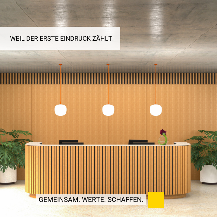 Büro mit Empfangsbereich in Holzoptik mit zwei Pflanzen links und rechts
